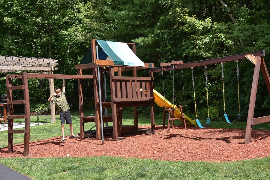 swing set with young boy giving thumbs up
