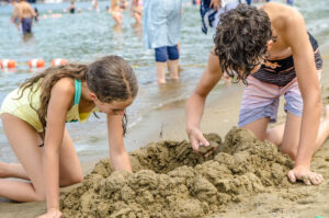 Digging a hole on a beach in Lake George